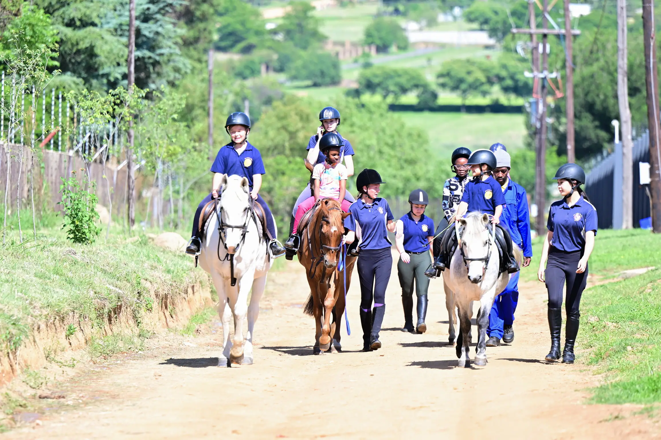 Group of young riders on horses with coaches at Sun Valley Stables, Kyalami