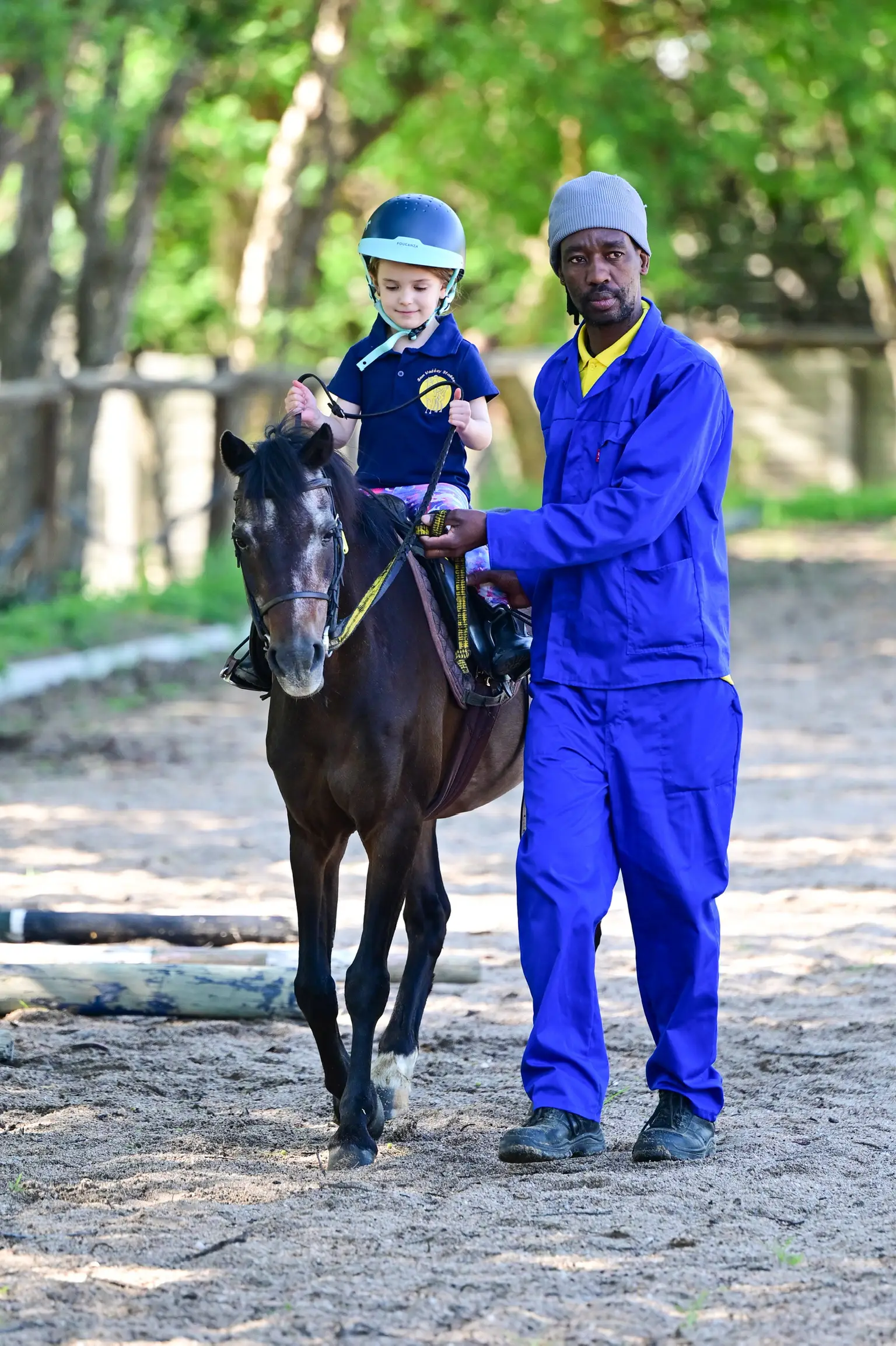 Young child on horseback being led by a groom at Sun Valley Stables, Kyalami
