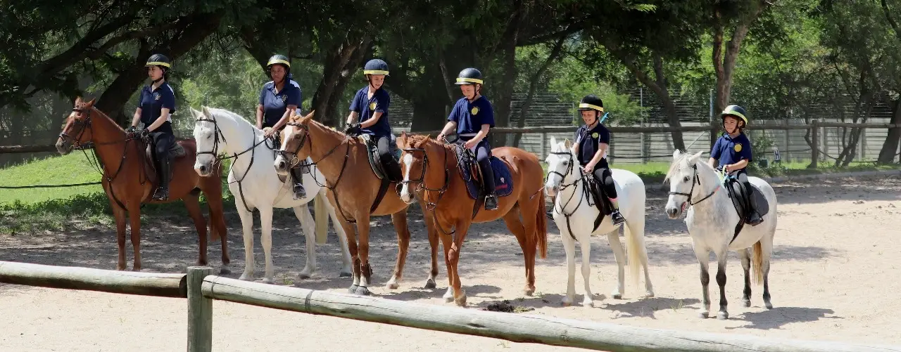 Group of Sun Valley Stables riders lined up on horses in the arena, Kyalami